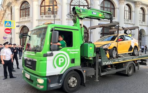 The taxi is towed away from the scene of the crash, just a few hundred yards from the Kremlin - Credit: Reuters