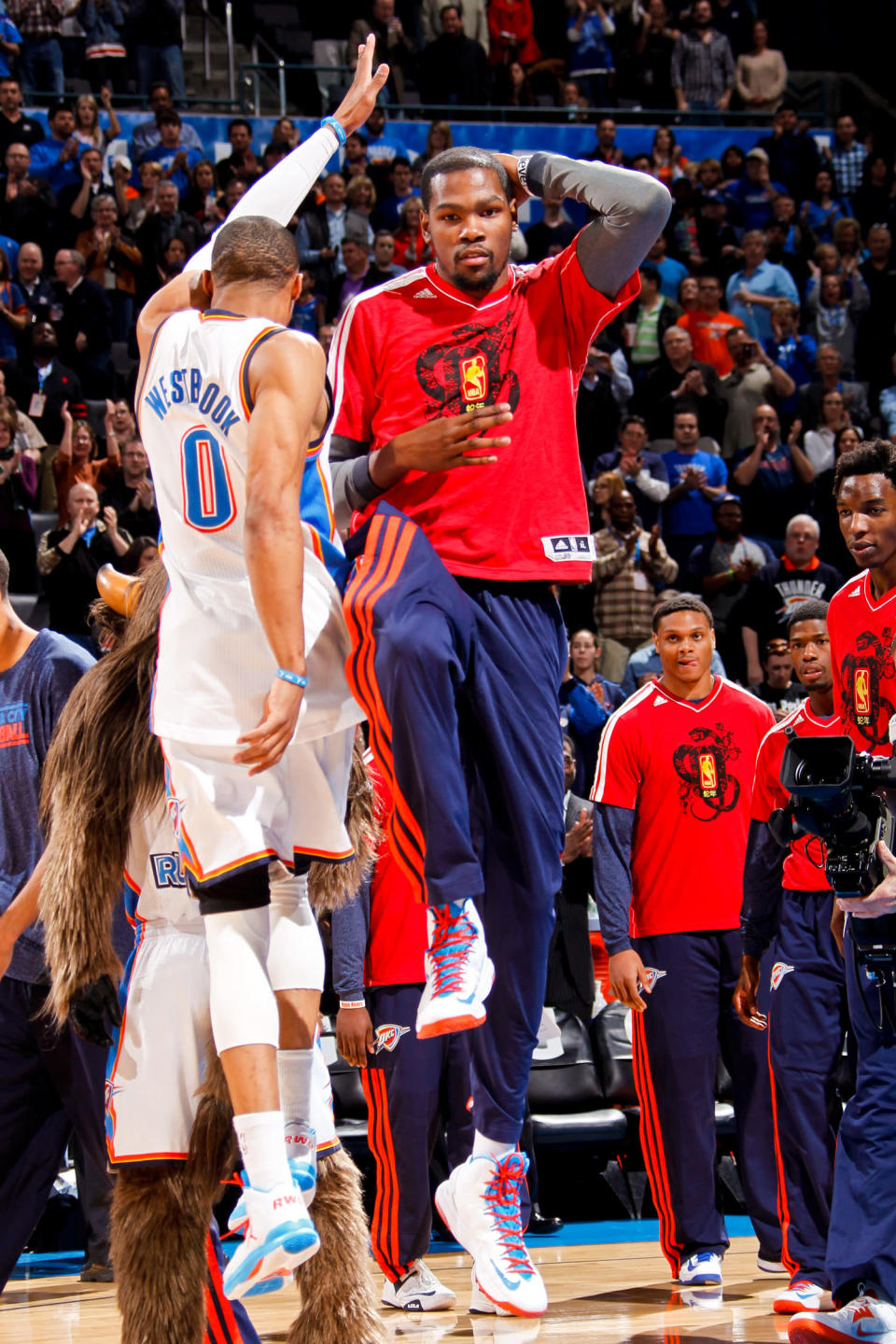 OKLAHOMA CITY, OK - FEBRUARY 8: Kevin Durant #35 of the Oklahoma City Thunder, wearing a shirt in honor of the Chinese New Year, greets teammate Russell Westbrook #0 before playing against the Phoenix Suns on February 8, 2013 at the Chesapeake Energy Arena in Oklahoma City, Oklahoma. NOTE TO USER: User expressly acknowledges and agrees that, by downloading and or using this photograph, user is consenting to the terms and conditions of the Getty Images License Agreement. Mandatory Copyright Notice: Copyright 2013 NBAE (Photo by Layne Murdoch Jr./NBAE via Getty Images)