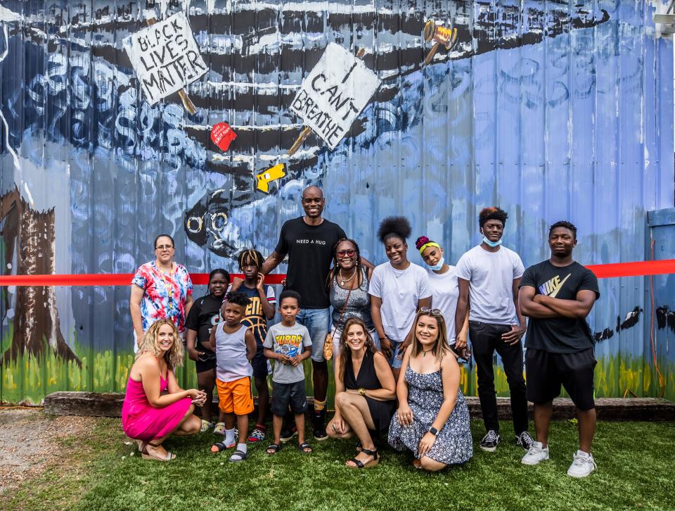 A mural created by artist Omari Booker and children from the Cheatam Place public housing community in North Nashville on the Local Distro building is unveiled Sunday, June 13, 2021.