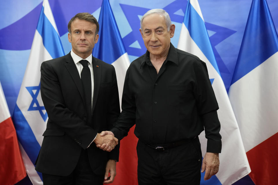 Israeli Prime Minister Benjamin Netanyahu, right, welcomes French President Emmanuel Macron before their talks in Jerusalem, Tuesday, Oct. 24, 2023. Emmanuel Macron is traveling to Israel to show France's solidarity with the country and further work on the release of hostages who are being held in Gaza. (AP Photo/Christophe Ena, Pool)