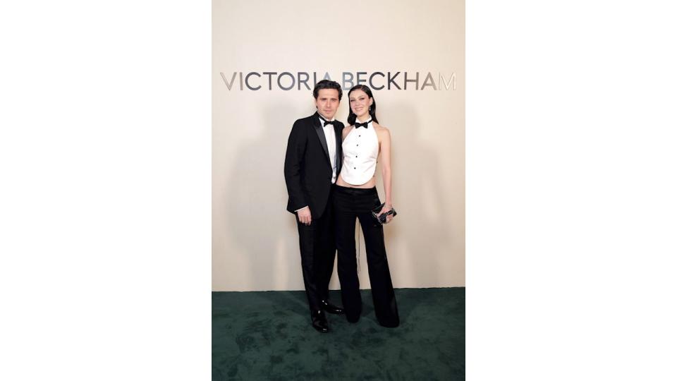 couple at fashion show in tuxedos 