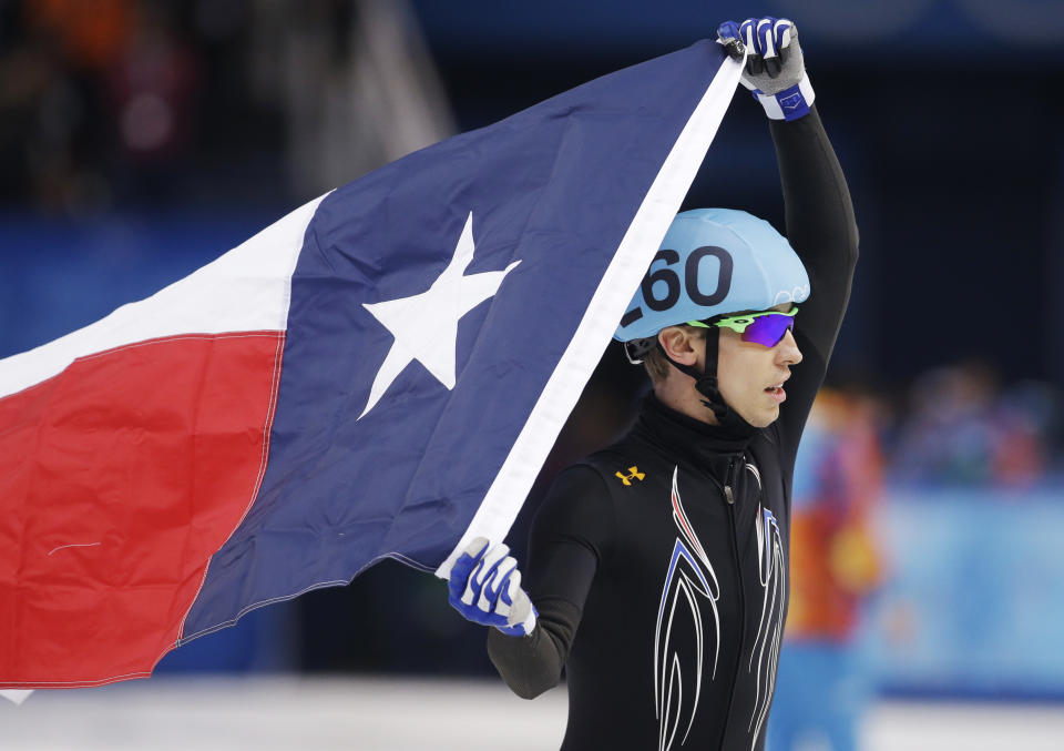 Jordan Malone of the United States celebrates their second place finish with the flag of Texas following the men's 5000m short track speedskating relay final at the Iceberg Skating Palace during the 2014 Winter Olympics, Friday, Feb. 21, 2014, in Sochi, Russia. (AP Photo/Darron Cummings)