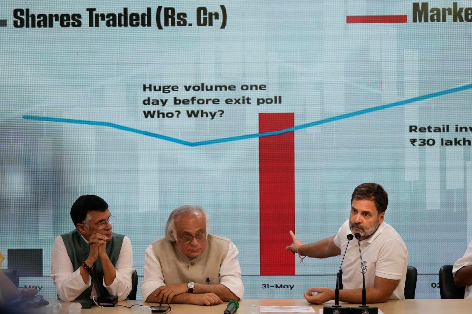 Congress party leader Rahul Gandhi, right, shows a stock market movement chart on a screen during a press conference in New Delhi, India, Thursday, 6 June 2024 (AP)