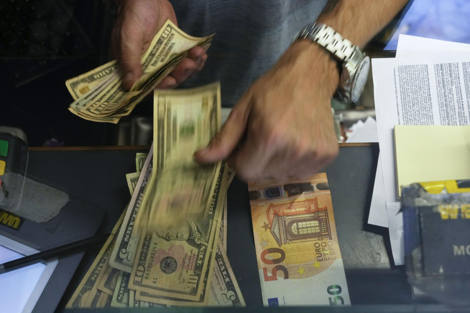 FILE - A cashier changes a 50 Euro banknote with US dollars at an exchange counter in Rome, Wednesday, July 13, 2022. Inflation in 19 European countries using the euro currency hits another record at 10% as energy prices soar. (AP Photo/Gregorio Borgia, File)