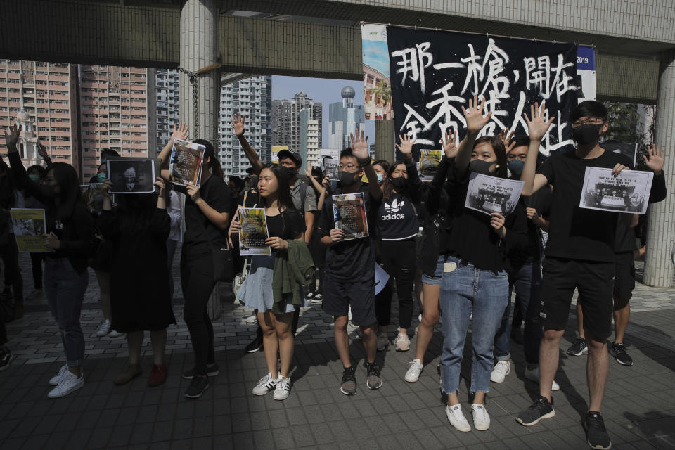 University students hold up their hands to represent the protesters' five demands at the campus of the University of Hong Kong, Wednesday, Nov. 6, 2019, as they protest against police brutality. The protests began in early June against a now-abandoned extradition bill that would have allowed suspects to be sent for trials in mainland China, which many saw as infringing of Hong Kong's judicial freedoms and other rights that were guaranteed when the former British colony returned to China in 1997. The banner with Chinese reads "The gun shot, fire to the bodies of all Hong Kong people". (AP Photo/Kin Cheung)