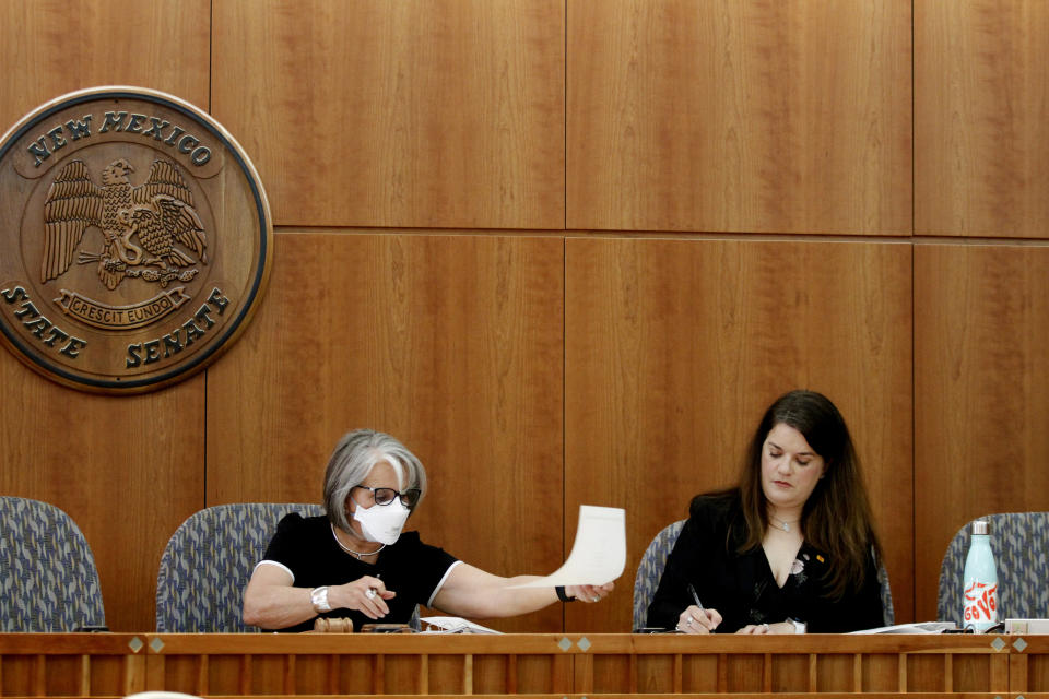 FILE - New Mexico Gov. Michelle Lujan Grisham, left, and Secretary of State Maggie Toulouse Oliver certify results of the state's primary election on June, 28, 2022, at the state Capitol in Santa Fe, N.M. Commissioners in a rural New Mexico county initially refused to certify the results of their June primary. They cited distrust of the voting systems used to tally the vote even though the county’s election official said there were no problems. (AP Photo/Morgan Lee, File)