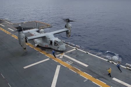 A landing signalman directs an MH-60S Sea Hawk, assigned to Helicopter Sea Combat Squadron 25, to land on flight deck of the amphibious assault ship USS Bonhomme Richard (LHD 6), flagship of the Bonhomme Richard Expeditionary Strike Group, operating in the South China Sea on October 6, 2016. Courtesy David Holmes/U.S. Navy/Handout via REUTERS