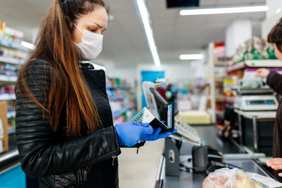 A woman checking out at the grocery store. (Photo: Getty)