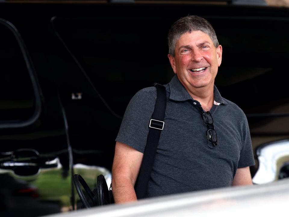 Jeff Shell smiles while holding bag