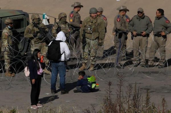 Migrantes piden la Guardia Nacional de Texas dejarles que se entreguen a la Patrulla Fronteriza en El Paso, Texas. / Getty Images