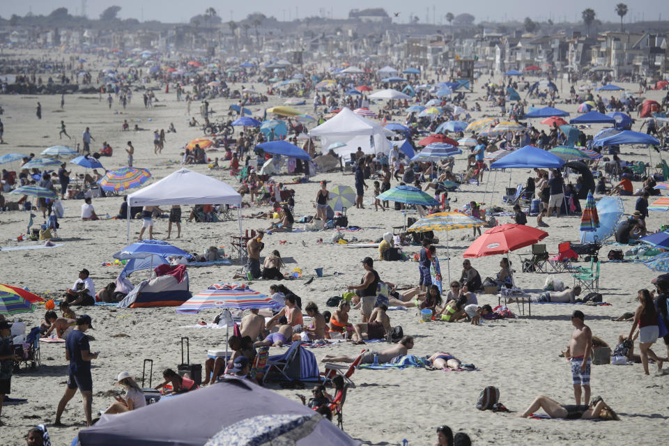 FILE - In this May 24, 2020, file photo, visitors gather on the beach during the Memorial Day weekend in Newport Beach, Calif. California's mood has gone from optimistic to sour as coronavirus cases and hospitalizations are on the rise heading into the July 4th weekend. Gov. Gavin Newsom has ordered bars and indoor restaurant dining closed in most of the state, many beaches are off limits, and he's imploring Californians to avoid holiday gatherings with family and friends. (AP Photo/Marcio Jose Sanchez, File)