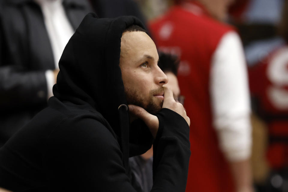 Golden State Warriors' Stephen Curry, watches Stanford from court-side during the first half of an NCAA college basketball game against UCLA on Monday, Feb. 20, 2023, in Stanford, Calif. (AP Photo/Josie Lepe)