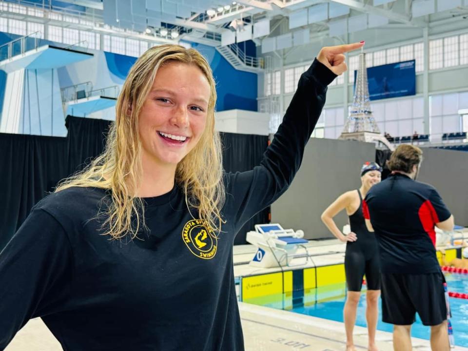 Summer McIntosh playfully points to a replica of the Eiffel Tower at the Pan Am pool in Toronto on Saturday. (Devin Heroux/CBC Sports - image credit)