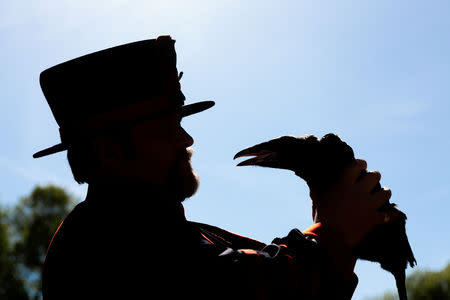 FILE PHOTO: Tower of London Ravenmaster Chris Skaife holds a baby raven in London, Britain May 14, 2019. Historic Royal Palaces/Handout via REUTERS.