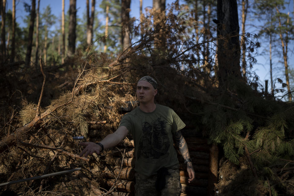 A Ukrainian soldiers throws a lighter to a colleague on the front line in the outskirts of Lyman, Ukraine, Tuesday, Aug. 15, 2023. Moscow’s army is staging a ferocious push in northeast Ukraine designed to distract Ukrainian forces from their counteroffensive and minimize the number of troops Kyiv is able to send to more important battles in the south. (AP Photo/Bram Janssen)