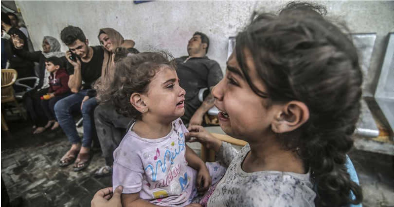 2名因以色列空襲而受傷的巴勒斯坦女童，在加薩走廊拉法市（Rafah）的難民營中放聲大哭。（圖／達志／美聯社）