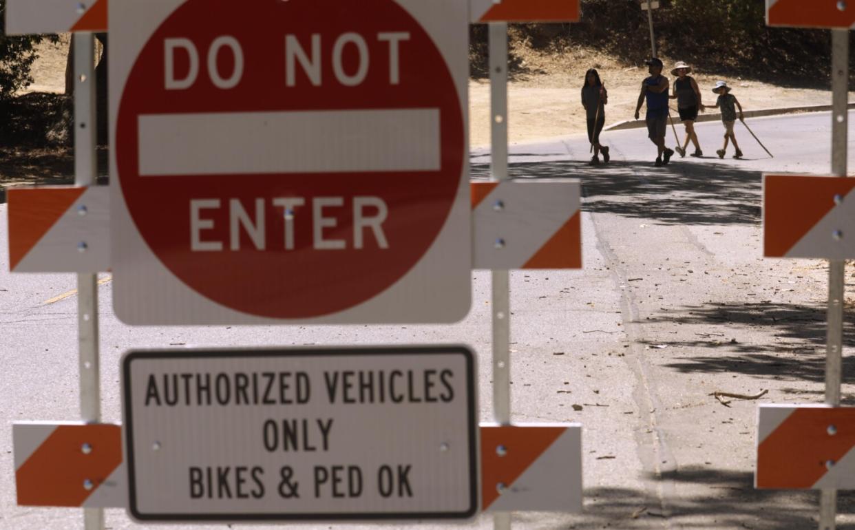 People walk in the distance, behind a "Do not enter" sign.