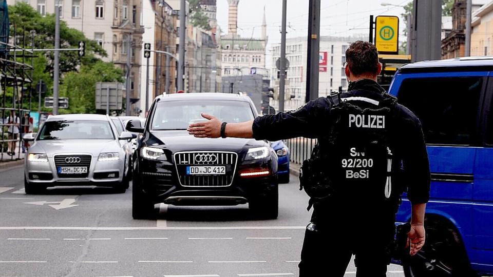 In Dresden leitet ein Polizist den Verkehr aufgrund der Absperrungen wegen des Bombenfunds um. Foto: Tino Plunert