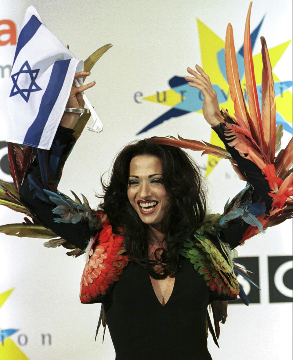 FILE - Israeli singer Dana International celebrates her victory in the Eurovision Song Contest at the Birmingham Indoor Arena, May 10, 1998, Birmingham England. Since 1956, the Eurovision Song Contest has provided catchy tunes, cheesy pop and bombastic anthems - but also some eye-catching fashion. (AP Photo/Louisa Buller, File)