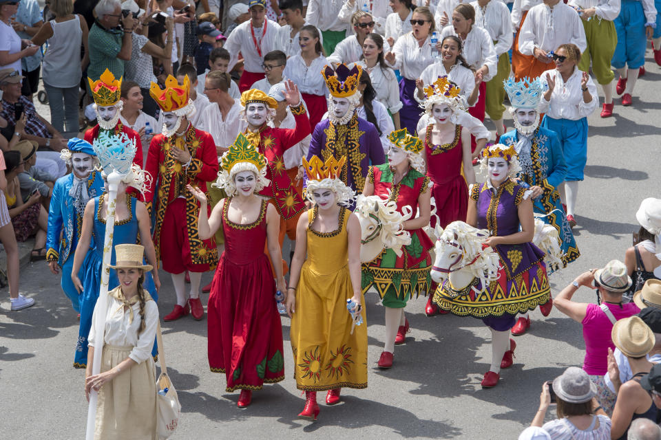 People take part of the "Fete des Vignerons" (winegrowers' festival in French), parade during the official opening parade prior to the first representation and crowning ceremony in Vevey, Switzerland, Thursday, July 18, 2019. Organized in Vevey by the brotherhood of winegrowers since 1979, the event will celebrate winemaking from July 18 to August 11 this year. (Laurent Gillieron/Keystone via AP)