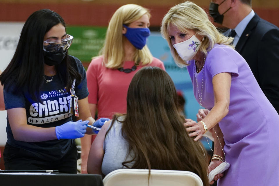 First lady Jill Biden comforts a person as they get a COVID-19 vaccination during a tour of the site at Isaac Middle School in Phoenix, Wednesday, June 30, 2021. (AP Photo/Carolyn Kaster, Pool)