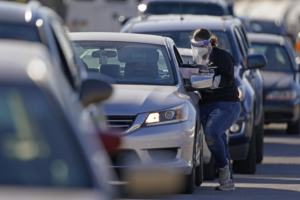 An election worker gives instructions to a voter at a drive-through polling location Tuesday, Nov. 3, 2020, in Kansas City, Mo. The location was established to provide access for people who have tested positive for COVID-19 and elderly voters. 