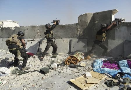 Members of the Iraqi Special Operations Forces take their positions during clashes with the al Qaeda-linked Islamic State of Iraq and the Levant (ISIL) in the city of Ramadi June 19, 2014. Picture taken June 19, 2014. REUTERS/Stringer