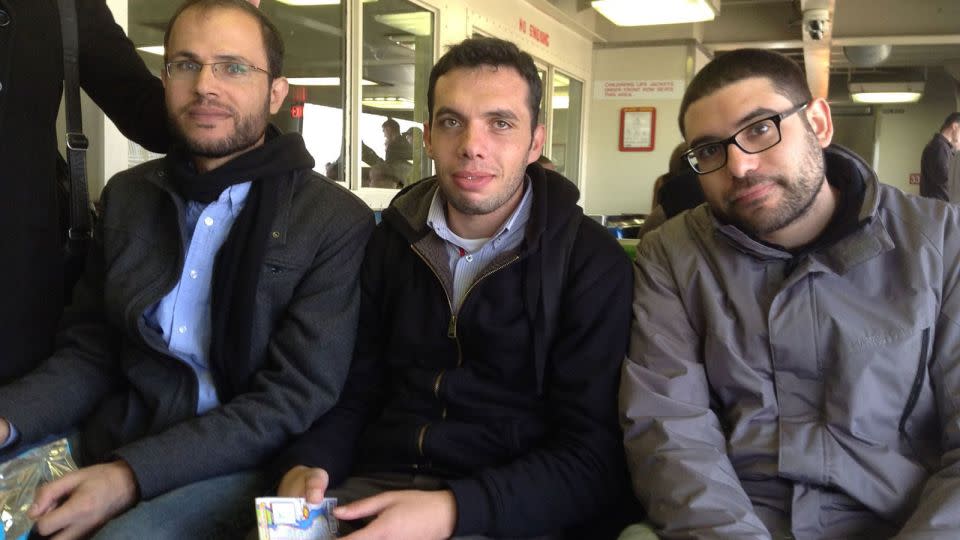 Refaat Alareer (left) sits with his friends and colleagues, Yousef Aljamal (center) and Jehad Abusalim (right), on the Staten Island Ferry in New York during a book tour in 2014. - Courtesy Jehad Abusalim