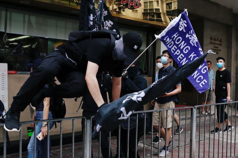 Un manifestante salta una reja durante protestas en Hong Kong, en desafío a la nueva ley de seguridad promulgada por China. Julio 1, 2020. REUTERS/Tyrone Siu