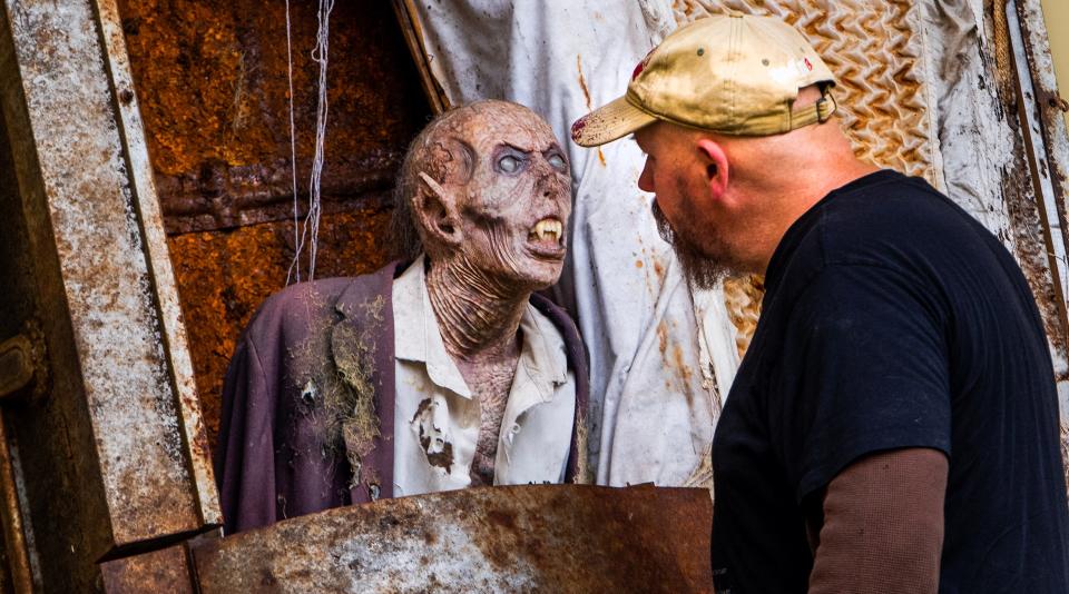 Jonathan Thornton takes a close look at a creature at his monster studio Oct. 5 in Montgomery.