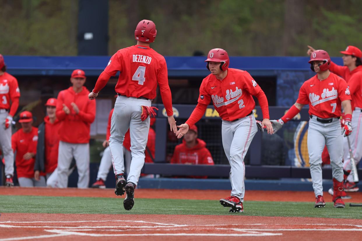 Ohio State shortstop Zach Dezenzo is greeted by his teammates at home plate after scoring during Wednesday night’s game against the Kent State Golden Flashes at Kent State's Schooner Stadium.