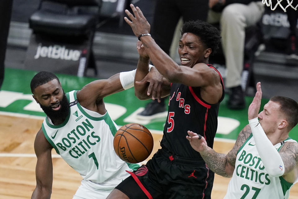 Boston Celtics guard Jaylen Brown (7) fouls Toronto Raptors forward Stanley Johnson (5) during the first half of an NBA basketball game, Thursday, March 4, 2021, in Boston. At right is Boston Celtics center Daniel Theis. (AP Photo/Charles Krupa)