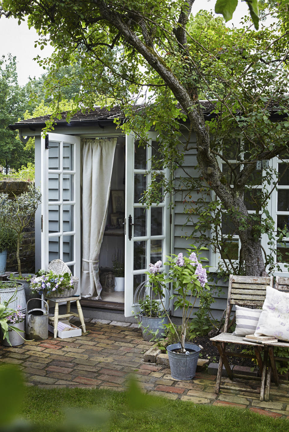 <p>Traditional wooden cladding in a subtle blue-grey brings rustic charm to this pretty garden studio, which serves as an extra room. </p>