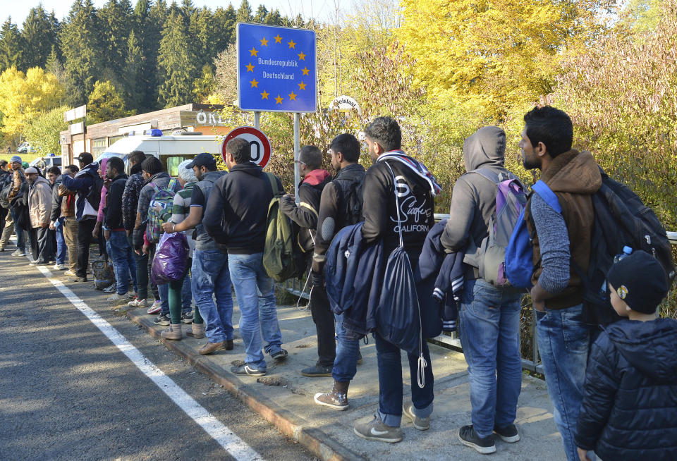 FILE - In this Wednesday, Oct. 28, 2015 file photo German federal police officers guide a group of migrants on their way after crossing the border between Austria and Germany in Wegscheid near Passau, Germany. A new study estimates that at least 3.9 million unauthorized migrants, and possibly as many as 4.8 million, lived in Europe in 2017 with half of them in Germany and the United Kingdom. (AP Photo/Kerstin Joensson, file)