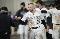 Colorado Rockies shortstop Trevor Story greets a field security guard during a ceremonial walk around the park after a baseball game Wednesday, Sept. 29, 2021, in Denver. The Rockies posted a 10-5 victory over the Washington Nationals. (AP Photo/David Zalubowski)