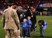 <p>Tresa McCormick of Killeen, Texas, hugs her husband, U.S Army Staff Sgt. James McCormick with their three sons at halftime in the Tostito’s Fiesta Bowl at the Sun Devil Stadium on January 1, 2005 in Tempe, Arizona. Tresa McCormick participated in the halftime “throw for charity” benefiting the USO. The Tostito’s brand team worked with the U.S. Army to bring McCormick home from his duties overseas for the surprise family reunion. (Photo by Harry How/Getty Images). </p>
