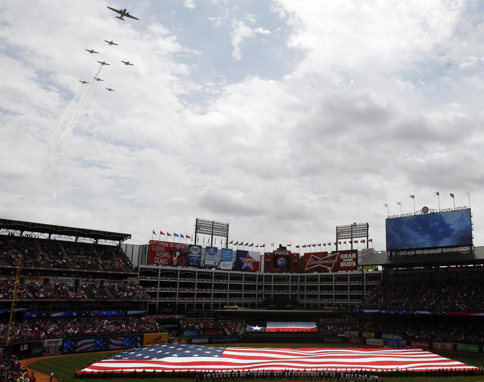 Vintage planes from the Cavanaugh Flight Museum fly over Globe Life Park before an opening day baseball game between the Texas Rangers and the Philadelphia Phillies, Monday, March 31, 2014, in Arlington, Texas. (AP Photo/Kim Johnson Flodin)