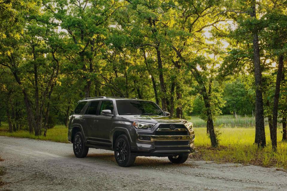 A dark-gray 2019 Toyota 4Runner on a tree-lined road.