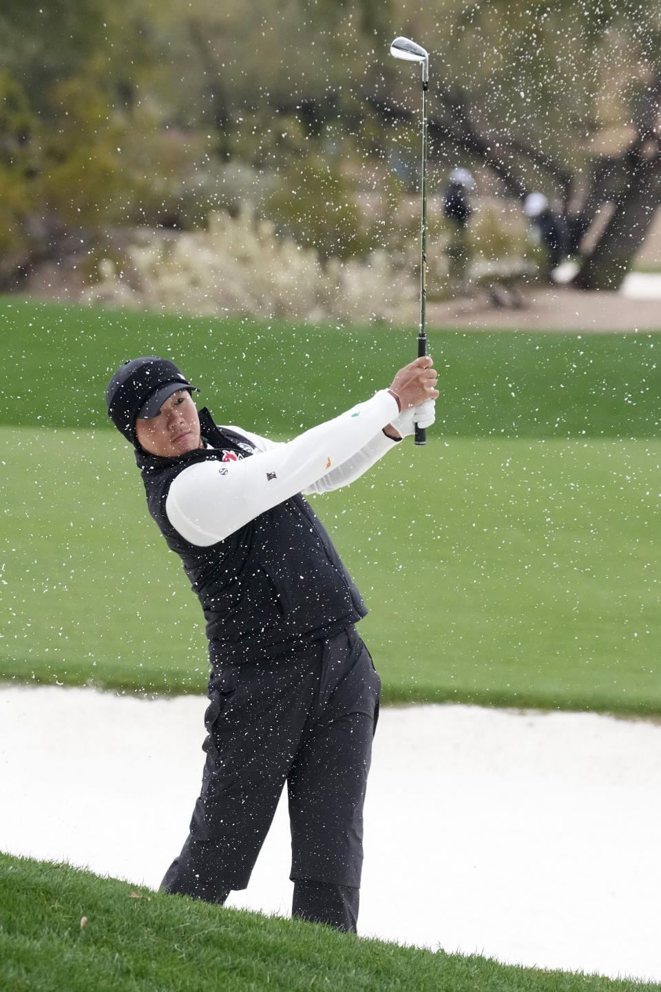 S.H. Kim, of South Korea, hits out of a fairway bunker on the second hole during the continuation of the second round of the Phoenix Open golf tournament Saturday, Feb. 10, 2024, in Scottsdale, Ariz. (AP Photo/Ross D. Franklin)