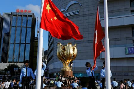 Pro-democracy activists climb the Golden Bauhinia sculpture during a protest to demand full democracy ahead of the 20th anniversary of the handover from Britain to China, in Hong Kong, China June 28, 2017. REUTERS/Tyrone Siu