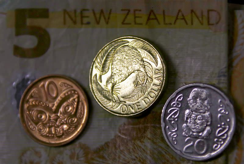 FILE PHOTO: A New Zealand dollar coin sits next to other coins and atop a five-dollar note in this photo illustration