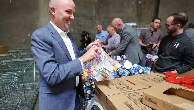 Gov. Spencer Cox puts together weekend food supplies for school children after announcing new service initiatives in the state at the Granite School District offices in West Valley City on Tuesday, Oct. 17, 2023.