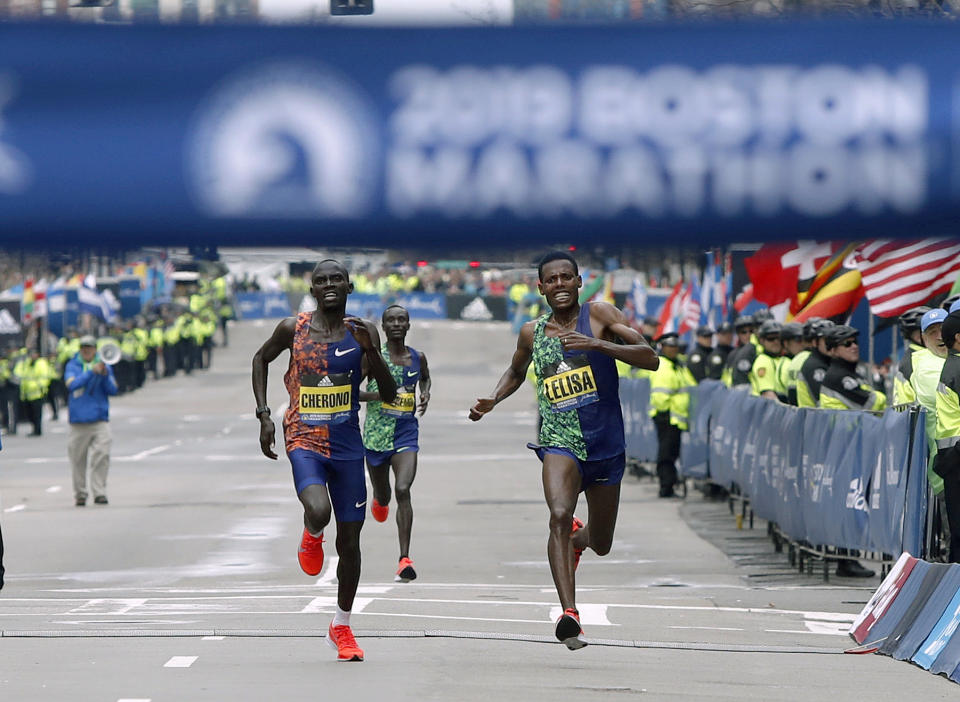 FILE - In this Monday, April 15, 2019, file photo, Lawrence Cherono, left, of Kenya, runs to the finish line to win the 123rd Boston Marathon in front of Lelisa Desisa, of Ethiopia, right, in Boston. The Boston Athletic Association said Wednesday, Oct. 28, 2020, that it won't hold the race as scheduled in April because of the COVID-19 pandemic. Organizers say it will be put off “at least until the fall of 2021.” This year's marathon was initially postponed until the fall and later canceled outright. (AP Photo/Winslow Townson, File)