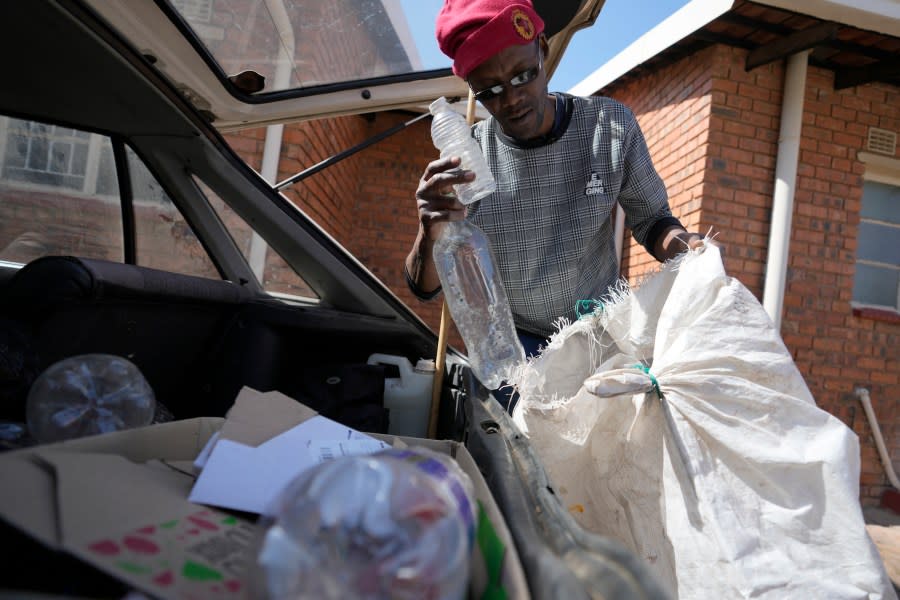 Themba Khumalo collects empty metal and plastic containers to sell in bulk for recycling and support his family in Daveyton township, east of Johannesburg, South Africa, Tuesday, Aug. 1, 2023. (AP Photo/Themba Hadebe)