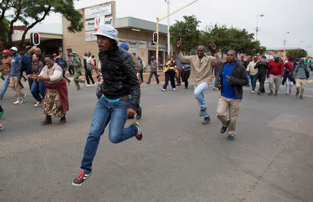 Protestors run through the streets of Pretoria, South Africa, February 24, 2017. REUTERS/ James Oatway.REUTERS/James Oatway