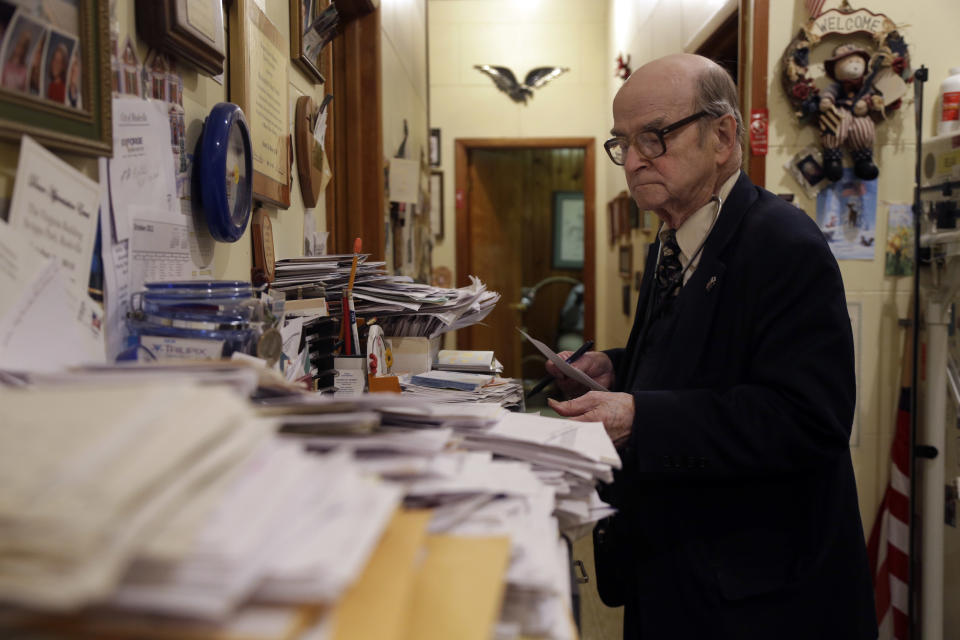 In this Tuesday, Oct. 30, 2012 photo, Dr. Russell Dohner looks over paper records between seeing patients in Rushville, Ill. His office has no fax machines, or computers, or other forms of modern technology. Medical records are kept on hand-written index cards, stuffed into row upon row of filing cabinets. (AP Photo/Jeff Roberson)