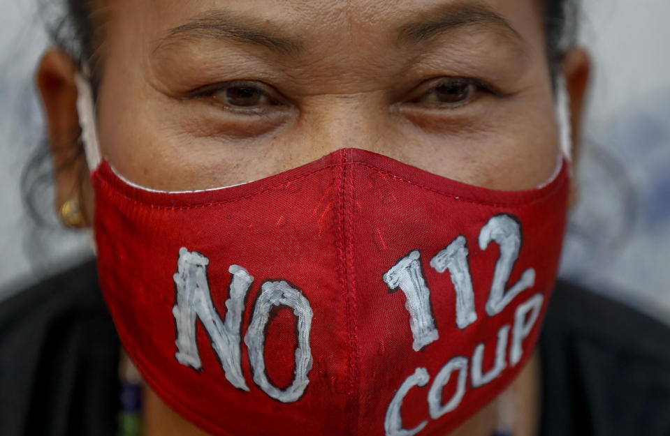 A pro-democracy supporter wears a face mask with the sign "no 112", denouncing a section in the Thai criminal code for lese majesty laws as she participates in a rally in Bangkok, Thailand, Wednesday, March 24, 2021, ahead of an indictment against 13 protest leaders on Thursday for allegations of sedition and defaming the monarchy. (AP Photo/Sakchai Lalit)