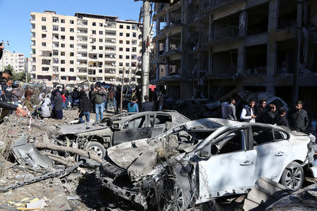 People look at buildings and cars, which were damaged during Friday's car bomb attack, in the Kurdish-dominated southeastern city of Diyarbakir, Turkey, November 5, 2016. REUTERS/Sertac Kayar