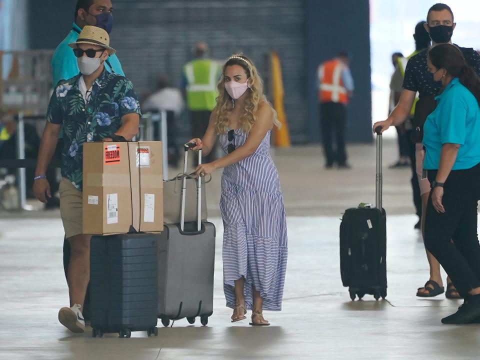 volunteer employees for Royal Caribbean's Freedom of the Seas Sailing walking and holding luggage