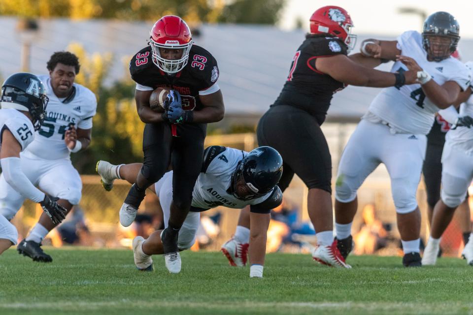 Oak Hills' Karson Cox shakes off a tackle during the first quarter on Friday, Aug. 18, 2023. Oak Hills beat Aquinas 42-15 in the season-opener.